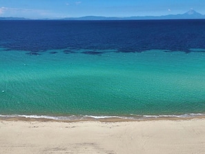 Uma praia com águas turquesa cristalinas e uma extensa faixa de areia.