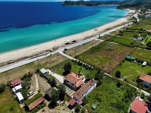 Vista aérea de una zona costera con playa, carretera y edificios residenciales.