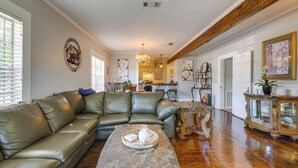 A living room with a leather sofa, a marble coffee table, and a chandelier. - Quiet Home Near I-49, Downtown & 2 Hospitals (Alexandria)