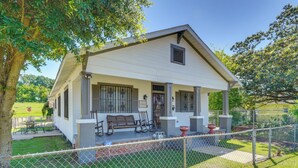 A white building with a porch, a bench, and a fenced yard. - Quiet Home Near I-49, Downtown & 2 Hospitals (Alexandria)