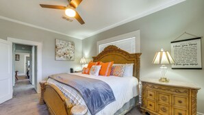 A bedroom with a bed, a nightstand, a dresser, a ceiling fan, and a wall with a framed quote. - Quiet Home Near I-49, Downtown & 2 Hospitals (Alexandria)