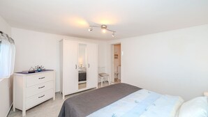 Ein Schlafzimmer mit Bett, Schminktisch, Stuhl und Kleiderschrank.