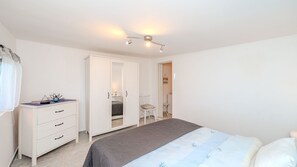Ein Schlafzimmer mit Bett, Schminktisch, Stuhl und Kleiderschrank.