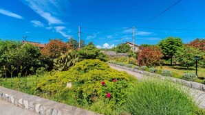 Ein Garten mit Steinmauer, Kakteen und blühenden Pflanzen.