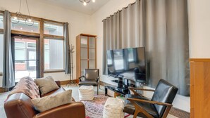 A modern living room with a leather sofa, a TV, and a wooden cabinet. - 3 Blocks to Dtwn! Cozy Sedro-woolley Retreat! (Sedro-Woolley)