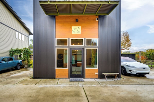 A modern building with a wooden facade, large windows, and a metal entrance.