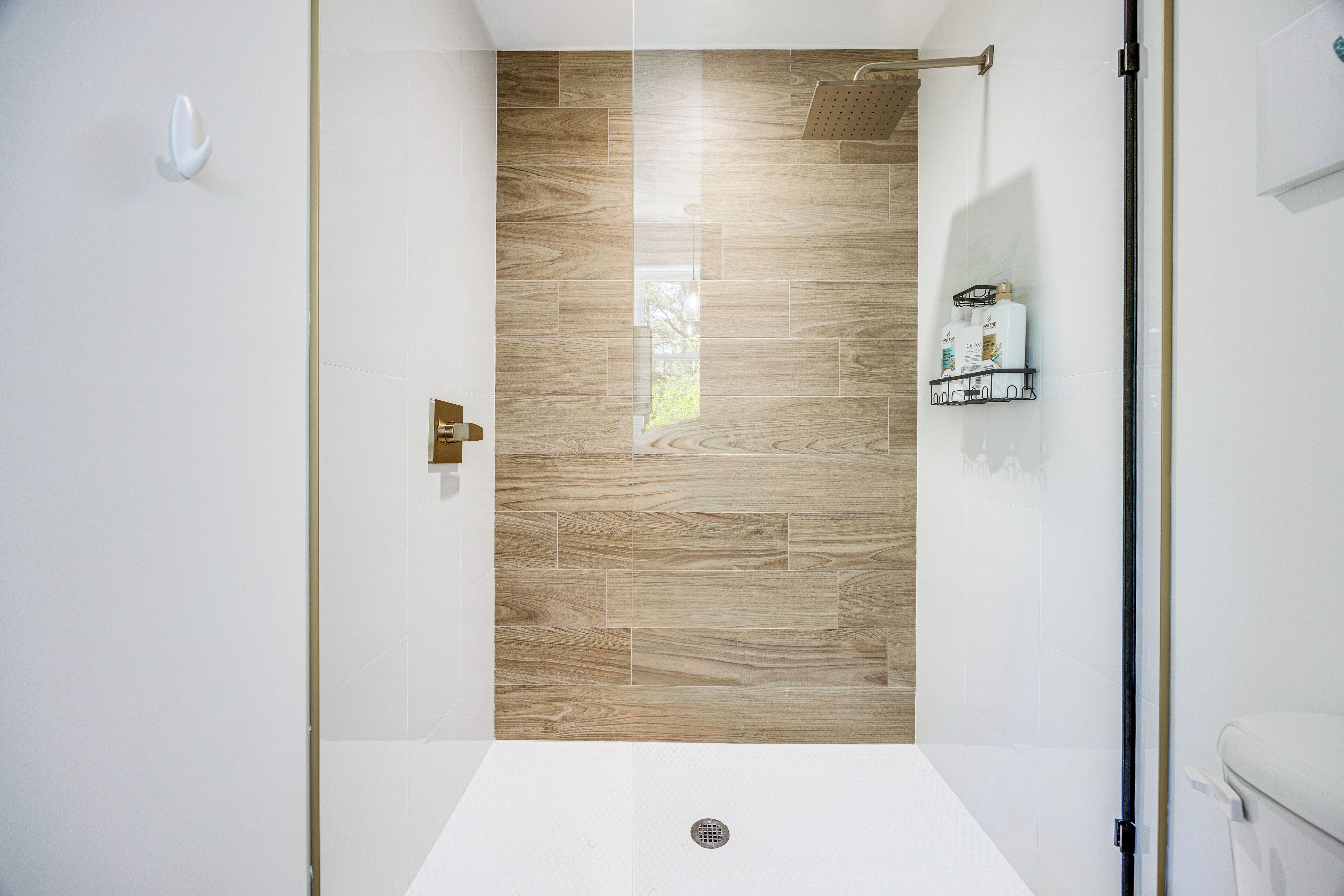 A modern bathroom with a shower, a toilet, and a sink.