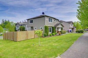 A two-story residential building with a fenced yard, a small tree, and a well-maintained lawn. - Walk to Trails & Golf: Sedro-woolley Retreat! (Sedro-Woolley)
