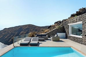 A pool with lounge chairs and a stone wall. - ONOMA Hotel Athens (Athens)