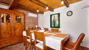 A dining area with a wooden table, chairs, and a cabinet.