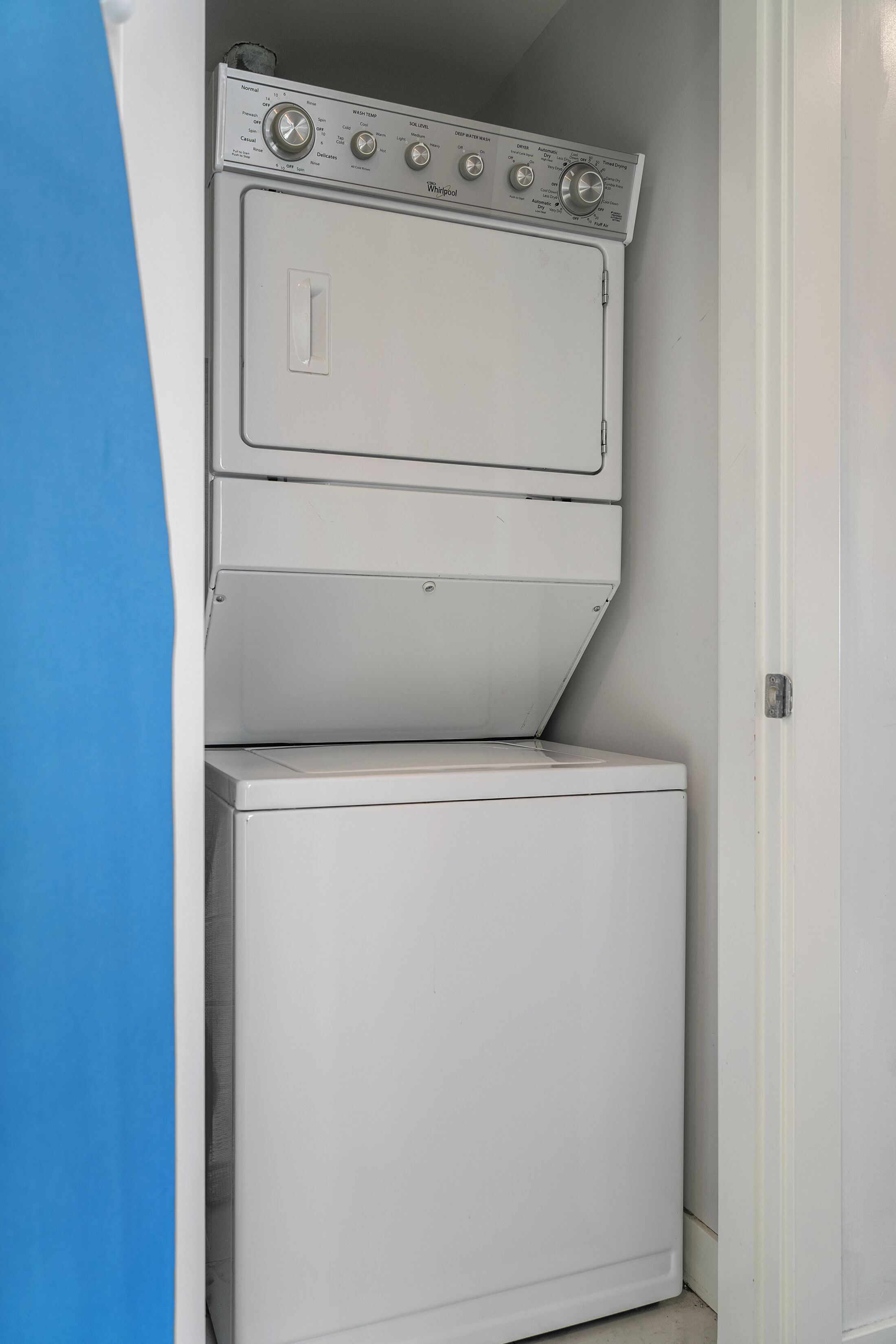 A compact, white, two-door washer and dryer unit with a control panel featuring multiple settings for washing and drying.