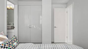 A bedroom with a bed, a wardrobe, and a door leading to another room.