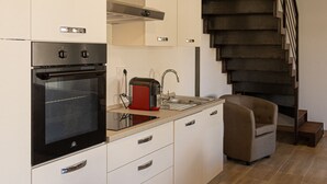 A modern kitchen with a built-in oven, a toaster, and a sink. There is a staircase leading to an upper level. - Résidence Dolce Vita  (Borgo)