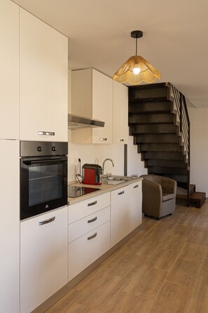 A modern kitchen with a built-in oven, a toaster, and a sink. There is a staircase leading to an upper level. - Résidence Dolce Vita  (Borgo)