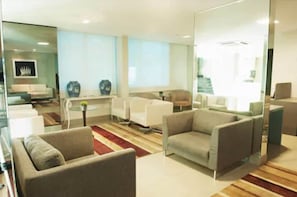 Un salon moderne comprenant un canapé, des fauteuils, une table basse et des vases décoratifs.