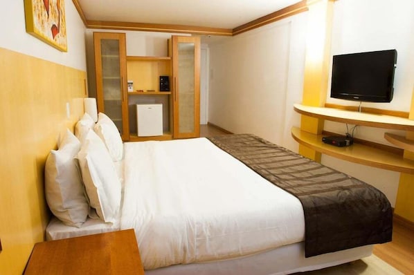 Une chambre d’hôtel équipée d’un lit, d’une télévision, d’un bureau et d’une armoire.