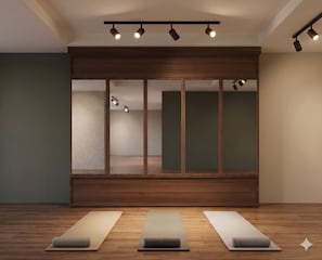 Una habitación con un armario de madera, tres colchonetas de yoga y luces en el techo.