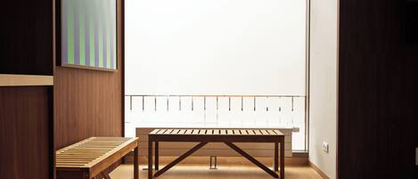 A room with a wooden floor, a table, and a bench.