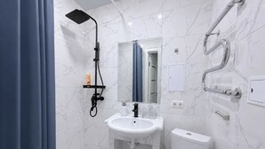 Ein Badezimmer mit Waschbecken, Toilette und Dusche.