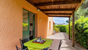 An outdoor patio with a table set for tea, a wooden pergola, and a view of greenery. - Holiday Home 'Casa Al Mare 482' with Shared Garden, Wi-Fi and Air Conditioning (Frassanito)