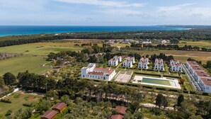 A large resort with multiple villas, a central pool, and a view of the ocean. - Holiday Home 'Casa Al Mare 482' with Shared Garden, Wi-Fi and Air Conditioning (Frassanito)