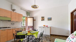 Una cocina compacta con comedor, un mueble pequeño y suelo de baldosas.
