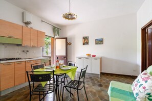 Eine kleine Küche mit Essbereich, einem Hängeschrank und Fliesenboden.