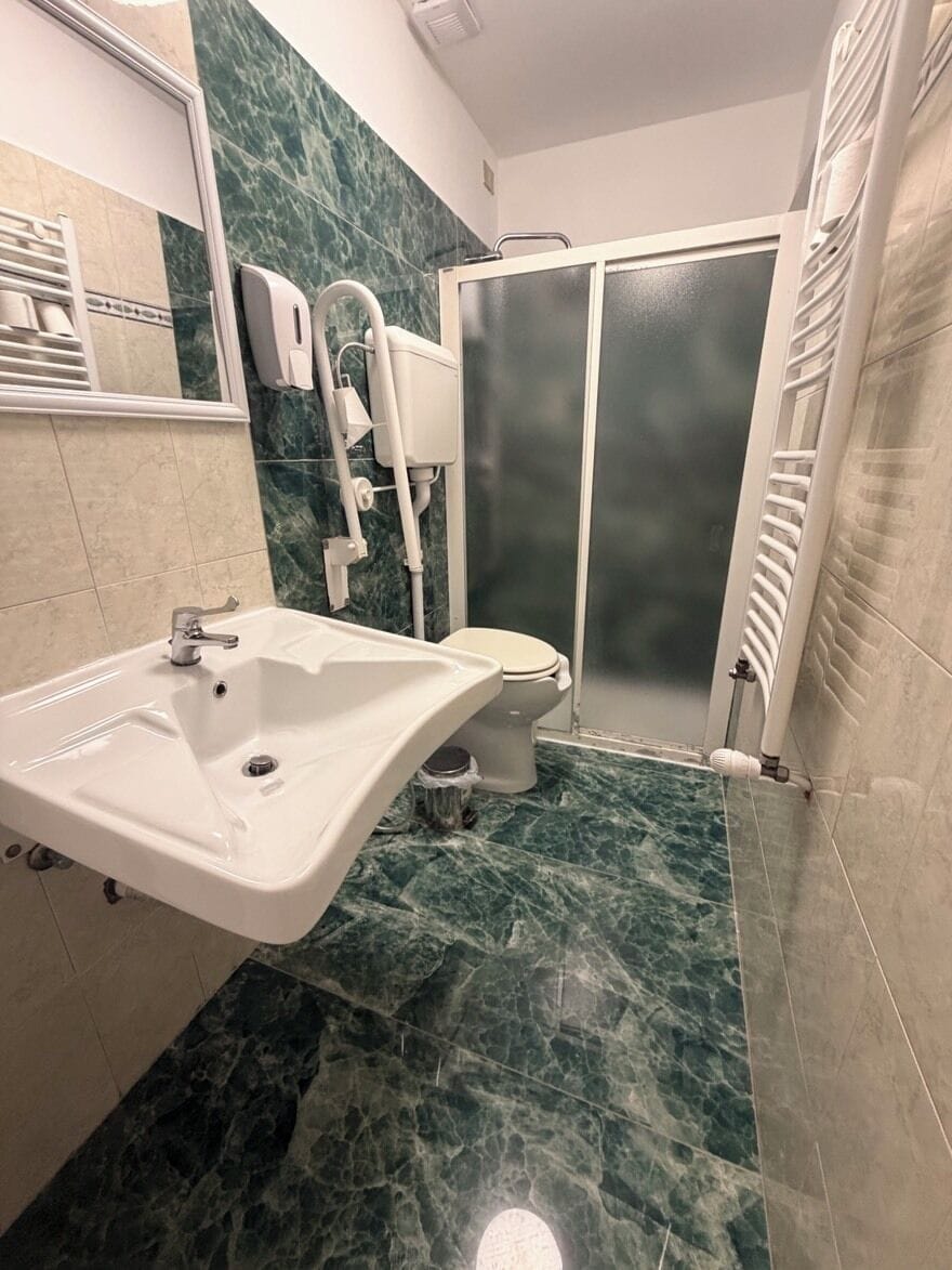 Ein Badezimmer mit Waschbecken, Toilette und Dusche.