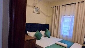 A hotel room with a bed, a ceiling fan, a window with curtains, and a small picture on the wall. - Makey Holiday Homes Diani (Diani Beach)