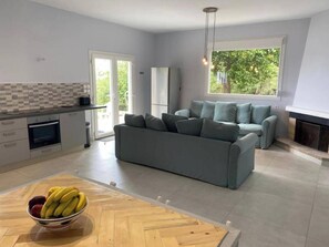 A modern kitchen with a dining area, a sofa, and a fireplace. - Villa - Sleeps 9 - Parking - Pool - Sea Views (Angon)