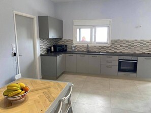 A kitchen with grey cabinets, a microwave, a sink, and a window. - Villa - Sleeps 9 - Parking - Pool - Sea Views (Angon)
