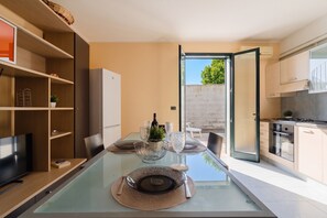 A modern kitchen with a dining area, a TV, and a view of the outdoors. - Holiday Home 'Casa Nicoletta a Otranto' with Private Terrace, Wi-Fi and Air Conditioning (Otranto)
