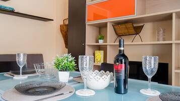 Mesa de jantar posta com taças de vinho, pratos e uma garrafa de vinho.