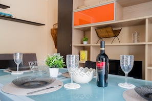 A dining table set with wine glasses, plates, and a bottle of wine. - Holiday Home 'Casa Nicoletta a Otranto' with Private Terrace, Wi-Fi and Air Conditioning (Otranto)
