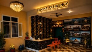 Uma área de recepção com piso xadrez, um balcão de atendimento e um lustre.