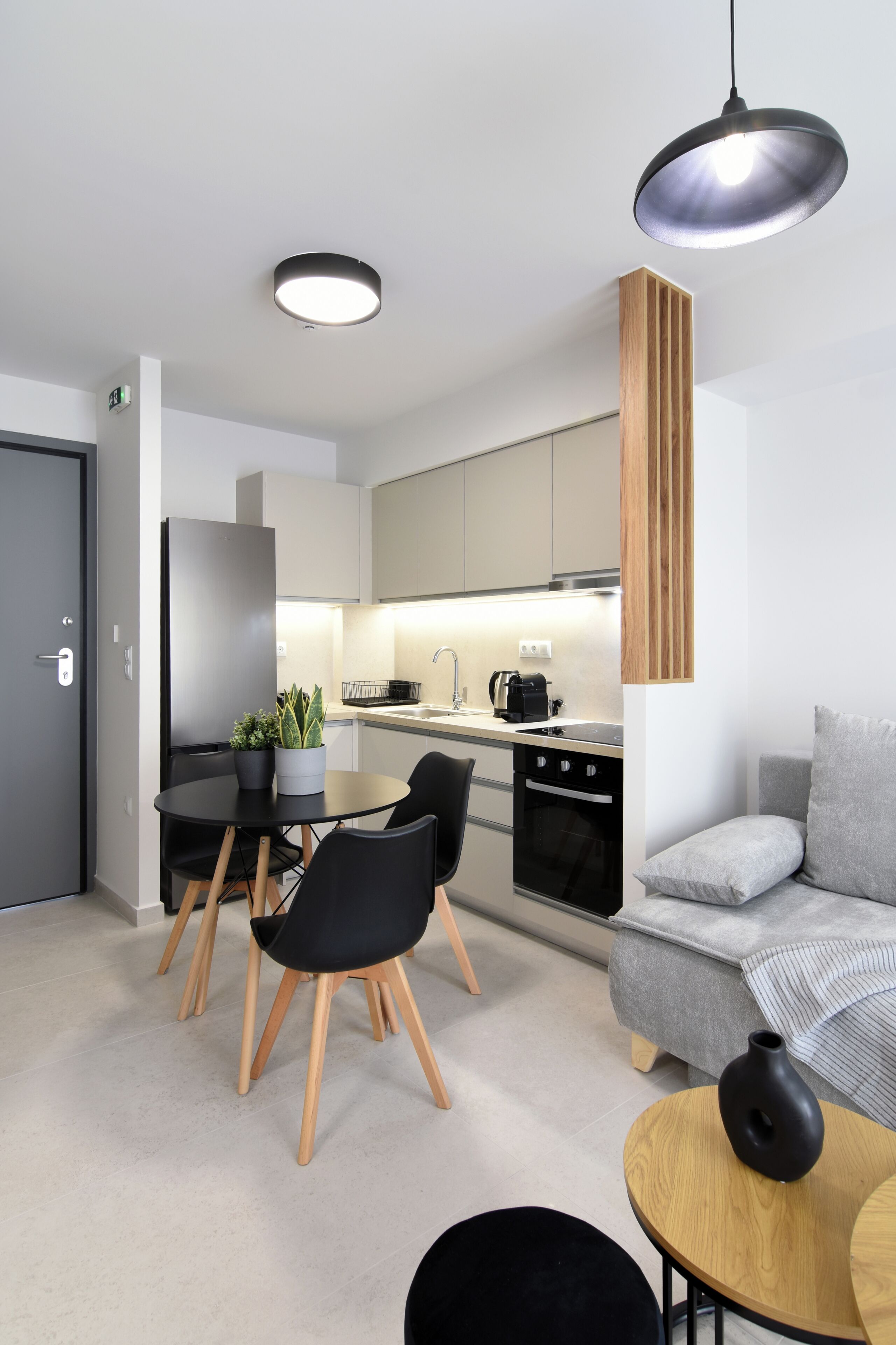 Una cucina moderna con zona pranzo, un divano e un tavolino con un vaso.