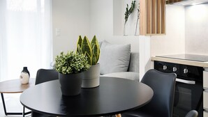 Una cocina moderna con una mesa de comedor negra, sillas de madera y una lámpara colgante.