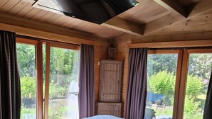 Un dormitorio con cama, escritorio y vistas a zonas verdes.