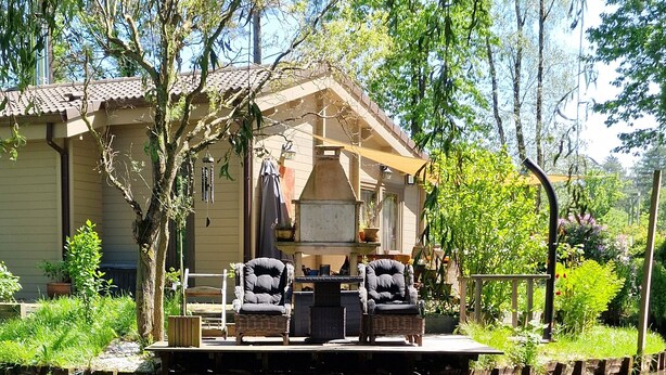 Una casa con un patio, dos sillas y una mesa.