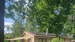 Una casa con techo de paneles solares, un estanque y vegetación circundante.