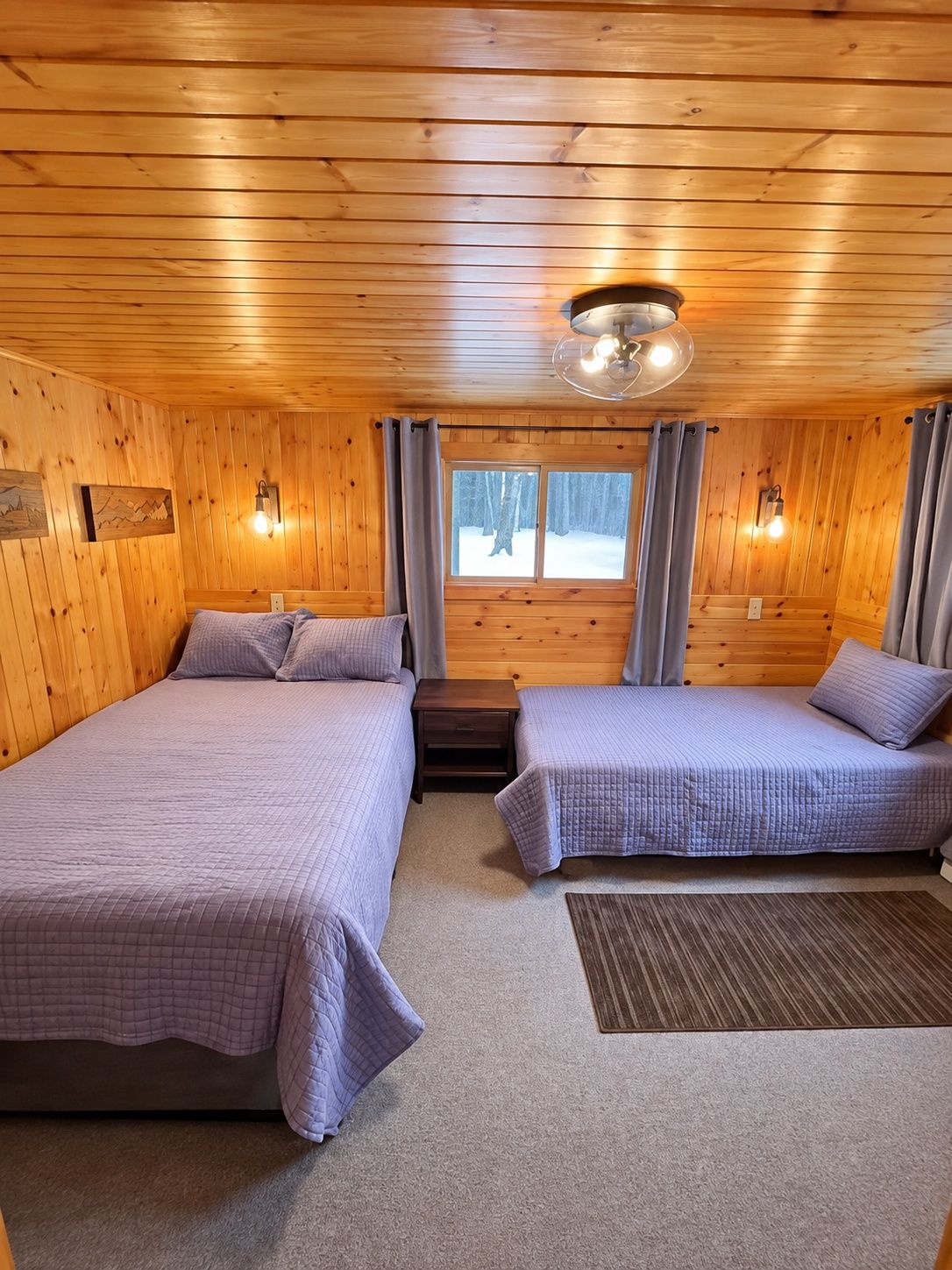 Cozy cabin bedroom with queen and twin beds for flexible sleeping
