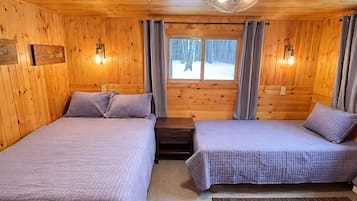 Cozy cabin bedroom with queen and twin beds for flexible sleeping