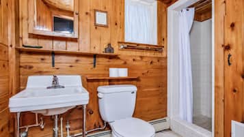 Rustic cabin bathroom with warm wood finishes and tiled walk-in shower
