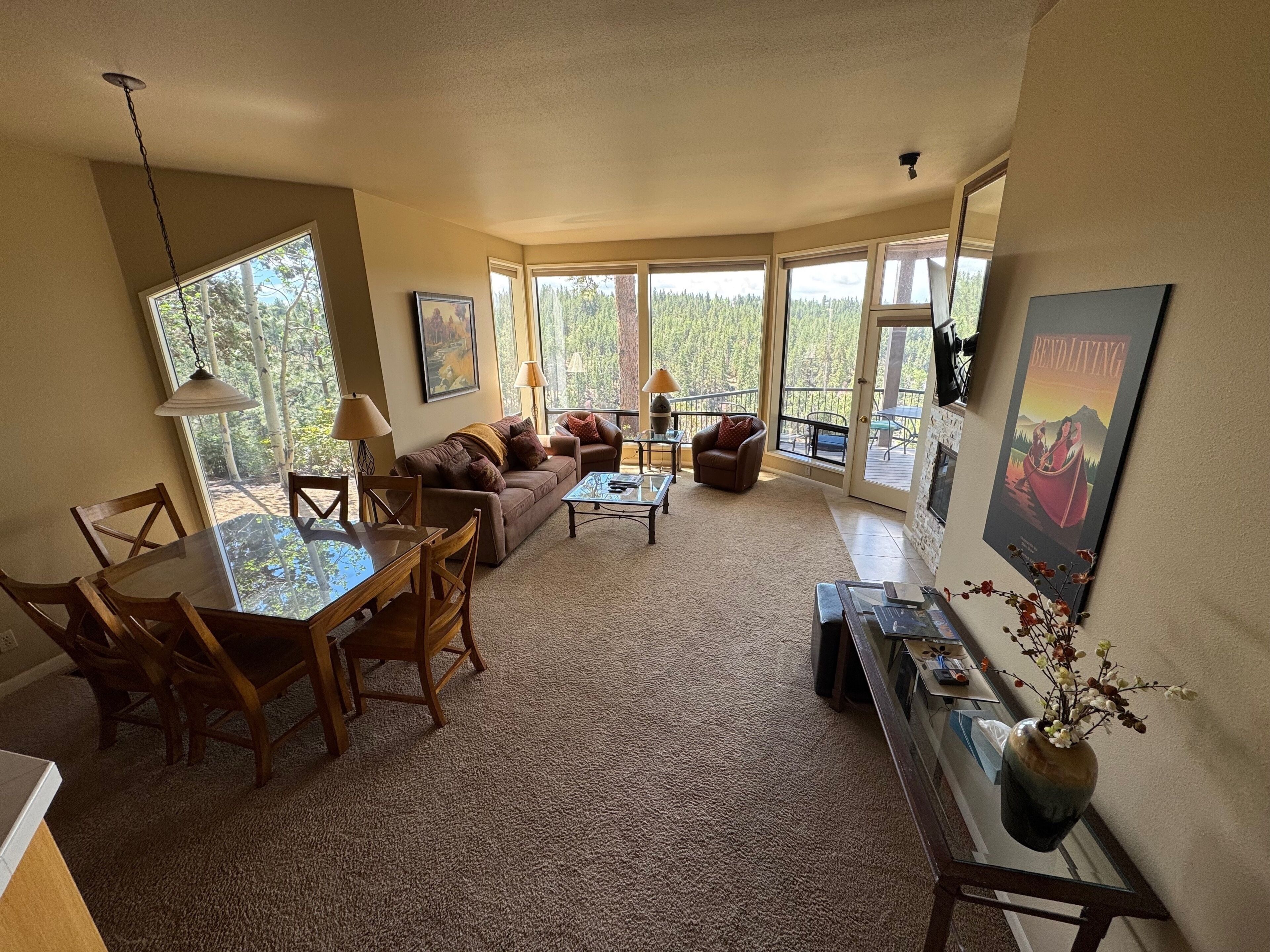 A spacious living area with a dining table, sofas, and a fireplace.