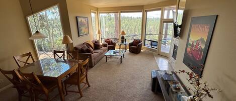 A spacious living area with a dining table, sofas, and a fireplace.