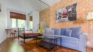 Uma sala de estar moderna com sofá, mesa de centro e cama com estrutura de madeira.