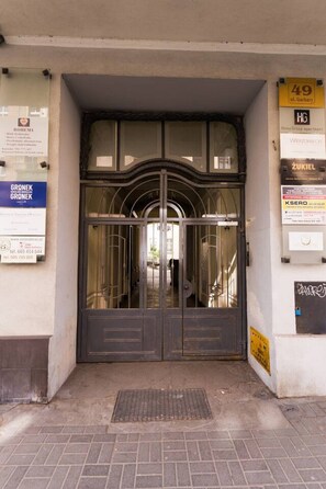 A building entrance with a double door, a sign for 'Home Group apartment' above it, and a '49 ul. Garbary' sign to the right. - Garbary Studio - Old Town, Top Location - by Rentujemy (Poznań)