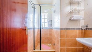 A bathroom with a shower, tiled walls, a sink, and a towel rack. - Kivulini luxurious and cozy apartment (Thika)