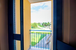 Ein Balkon mit Blick auf einen grünen Park und Gebäude.