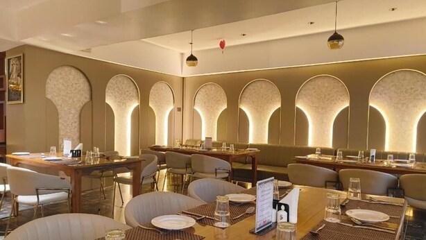 Un restaurante con varias mesas, sillas y una decoración interior moderna.